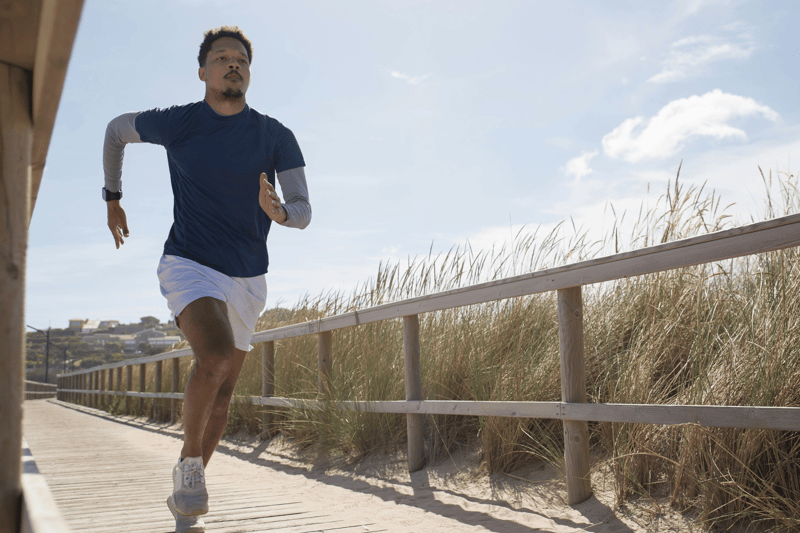Man running outdoors on a coastal boardwalk