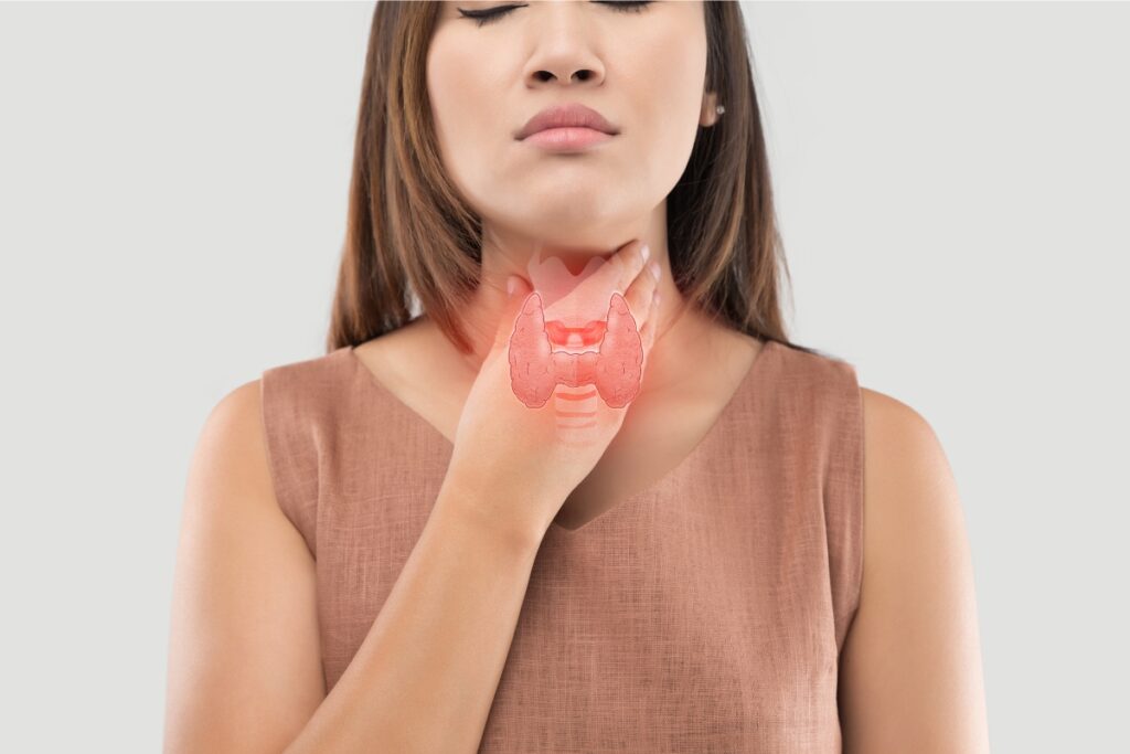 woman holding her throat representing thyroid
