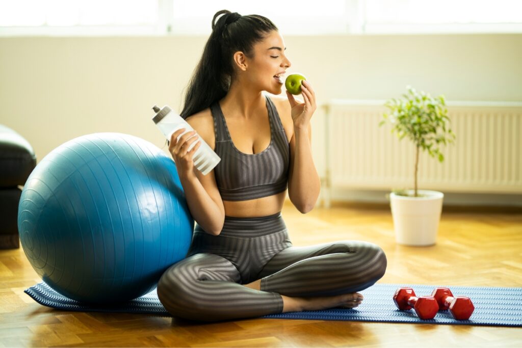 fit woman eating and drinking healthy after doing an exercise